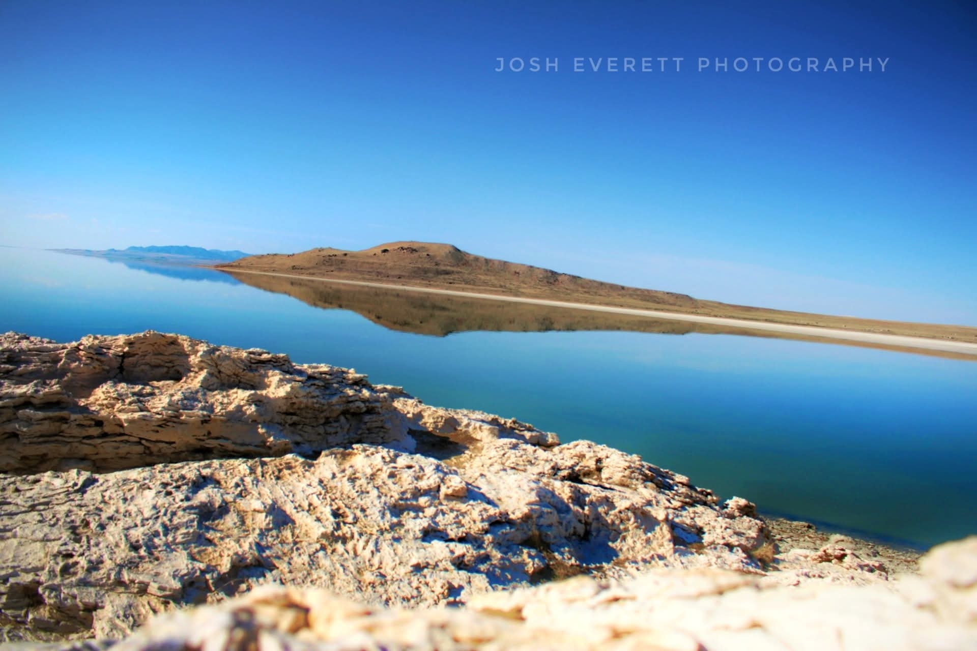 Still lake reflecting desert hill